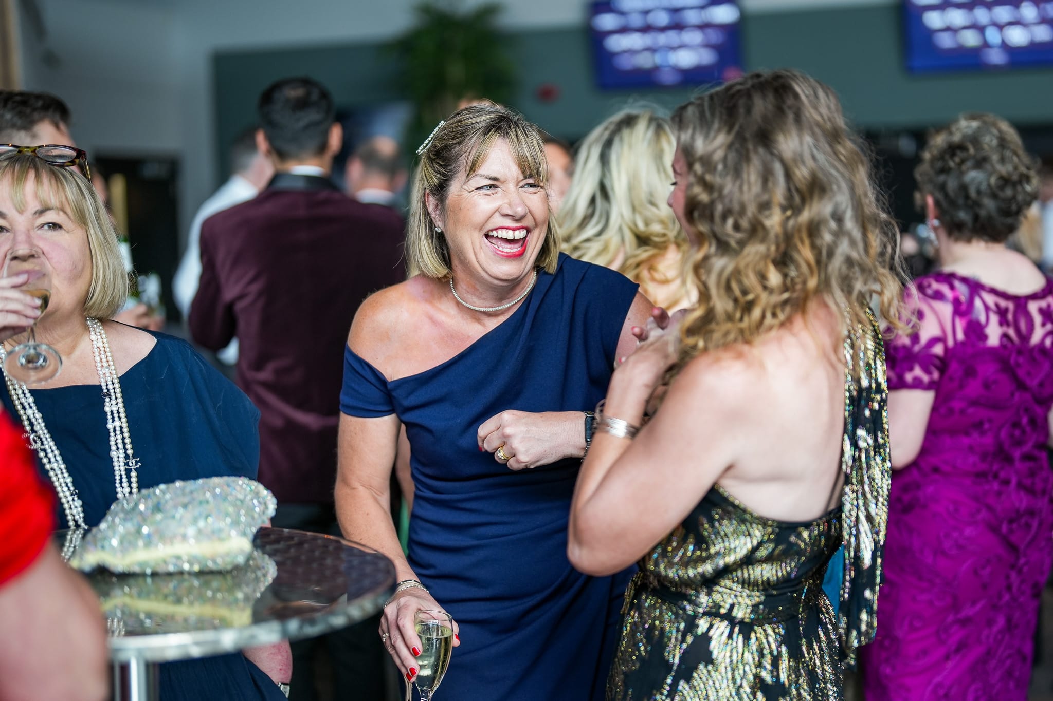 A guest laughing with friends during the drinks reception